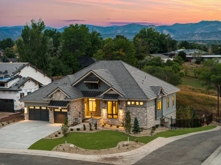 Twilight aerial of a Colorado home with foothills behind