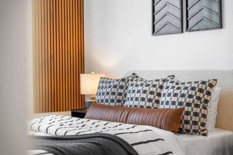 Styled bedroom with patterned pillows and wood accent wall