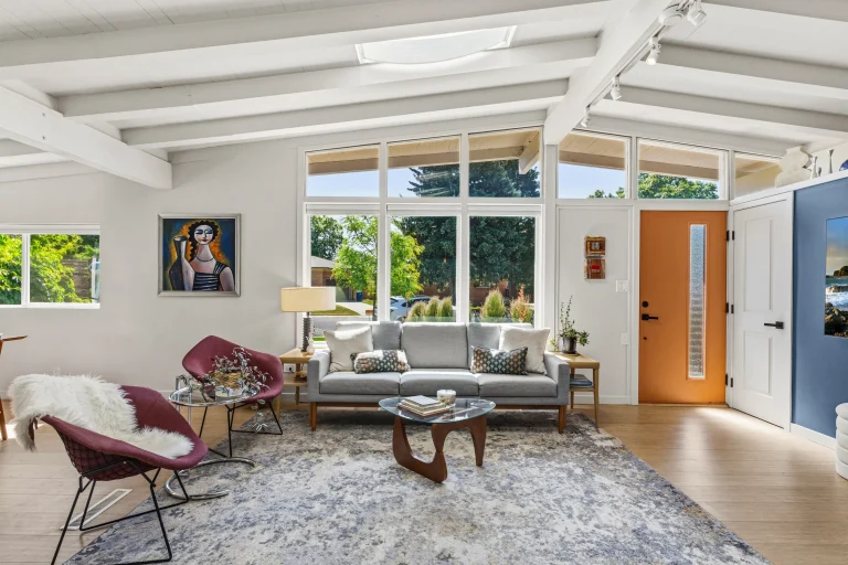 Open living room with beamed ceiling and large windows