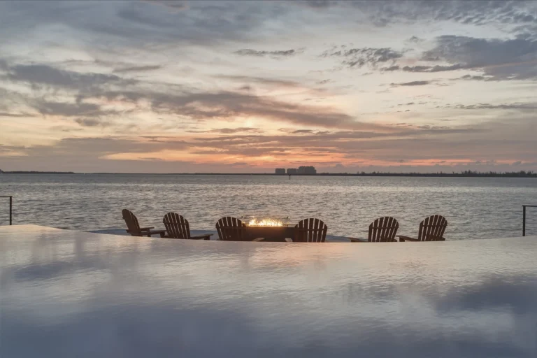 Waterfront patio with fire pit at sunset