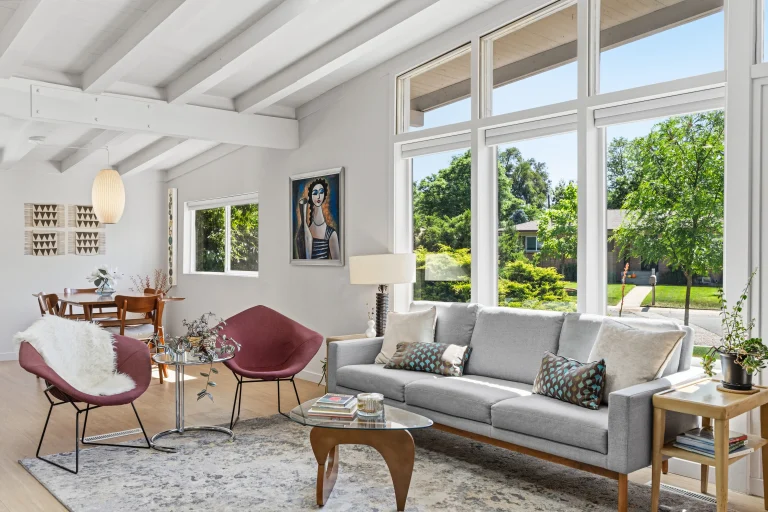Living room with beamed ceiling and garden windows