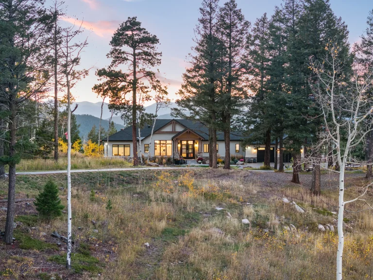 Mountain home among pine trees at sunset