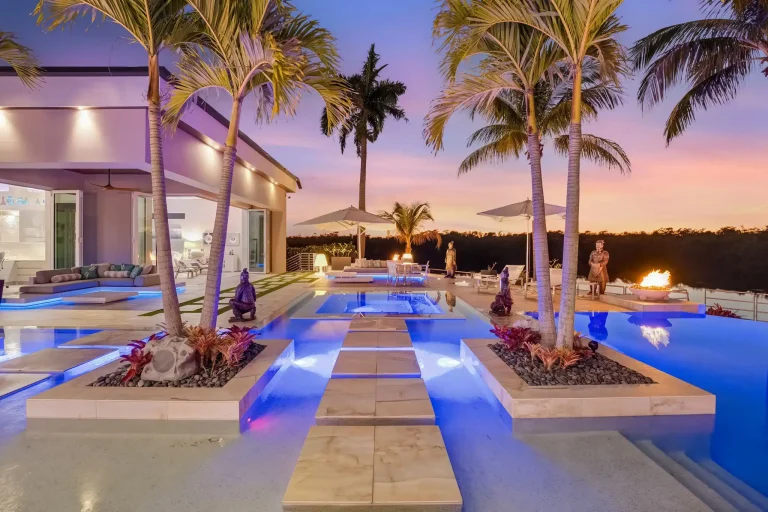 Lit pool with stepping stones and fire features at dusk