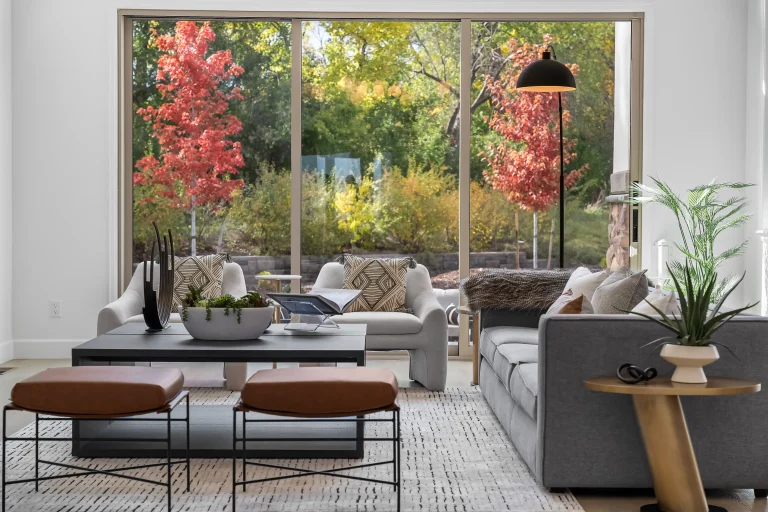 Living room with floor-to-ceiling windows and autumn trees