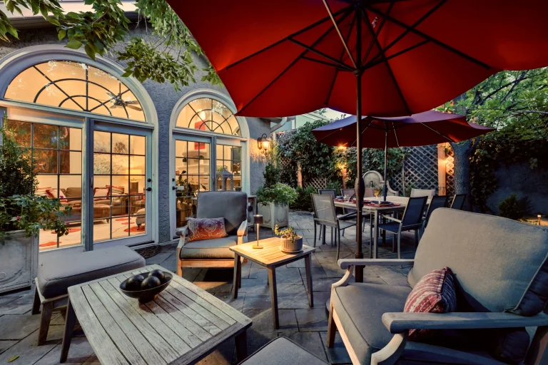 Covered patio with red umbrella and lounge seating