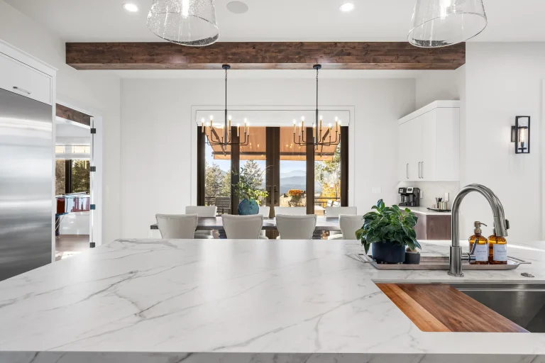 Marble kitchen island with wood beam and pendants