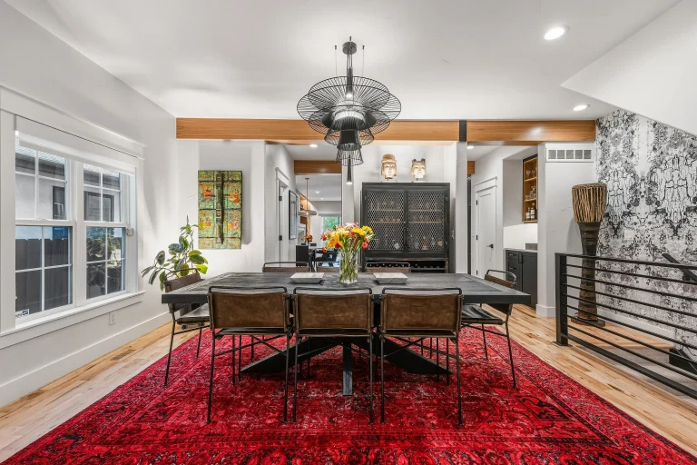 Dining room with red rug and staircase