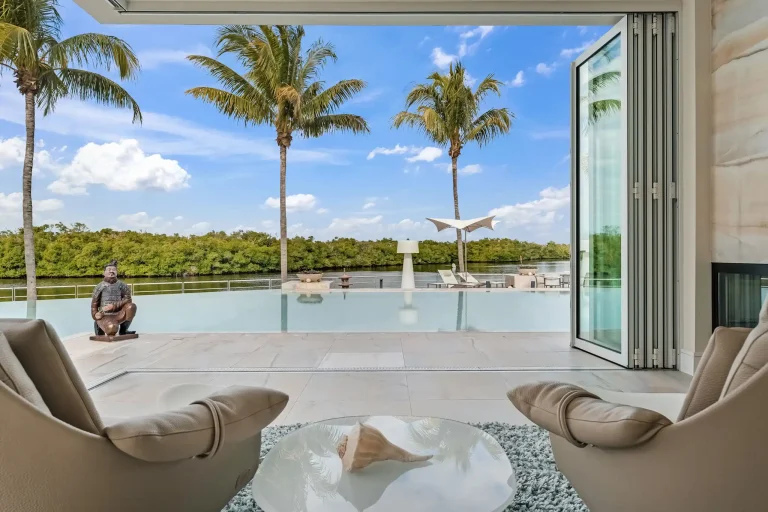 View from a lanai over an infinity pool and palm trees in Florida