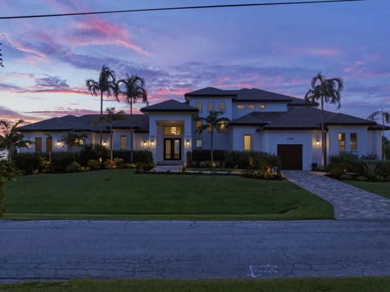 Twilight exterior of a Florida home framed by palm trees